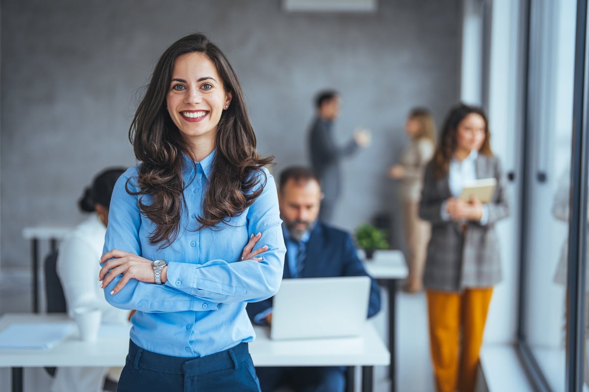 Successful businesswoman standing in creative office and looking at camera, portrait of beautiful business woman