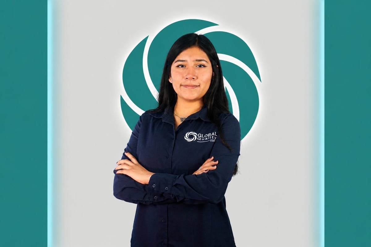 Professional woman with crossed arms wearing navy blue branded jacket, standing in front of teal spiral logo background