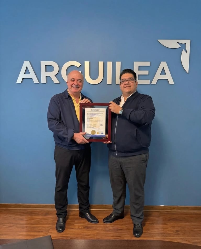 Two men in business suits holding a framed certificate in front of an ARQUILEA blue wall logo