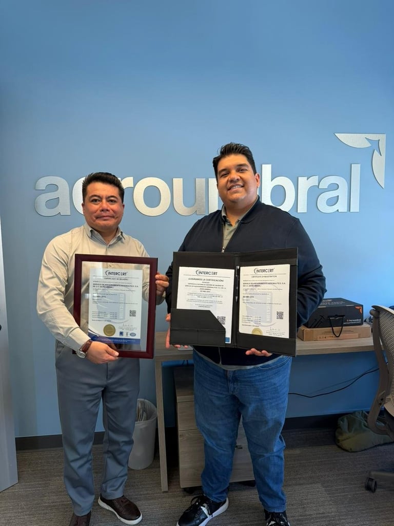 Two men holding framed certificates in front of a blue wall with a company logo