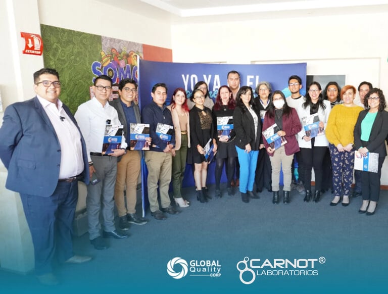 Large group of professionals posing together at an event with Global Services and Carnot Laboratories branding visible