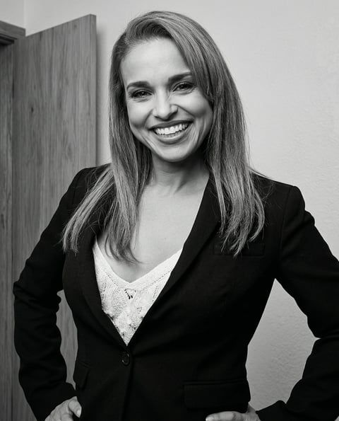 Profesional sonriente con cabello oscuro y blazer negro